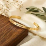 Personalized Golden Name Bracelet on a light display cushion