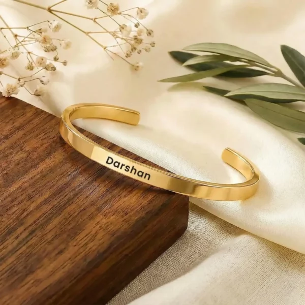 Personalized Golden Name Bracelet on a light display cushion