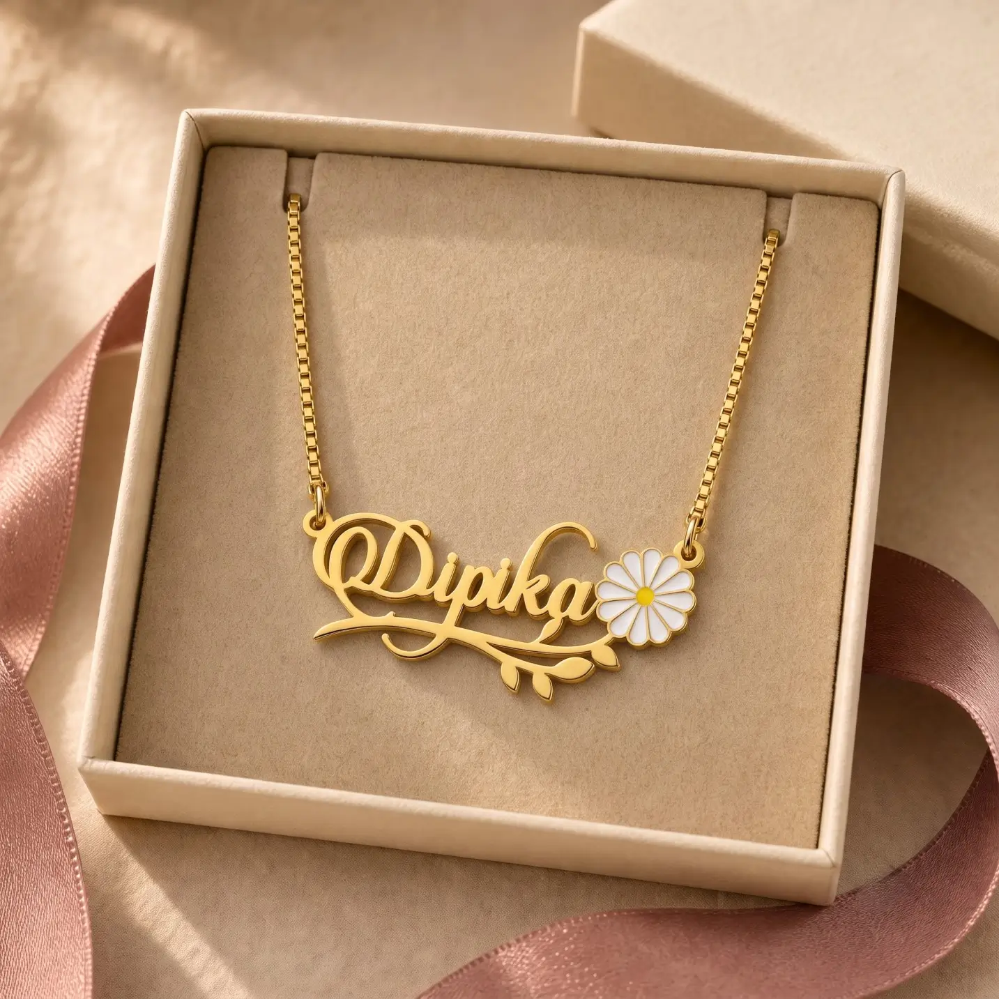 Flower and Leaf Name Necklace - Jewellery Box Gold-tone daisy and leaf name necklace displayed in an open beige jewellery box