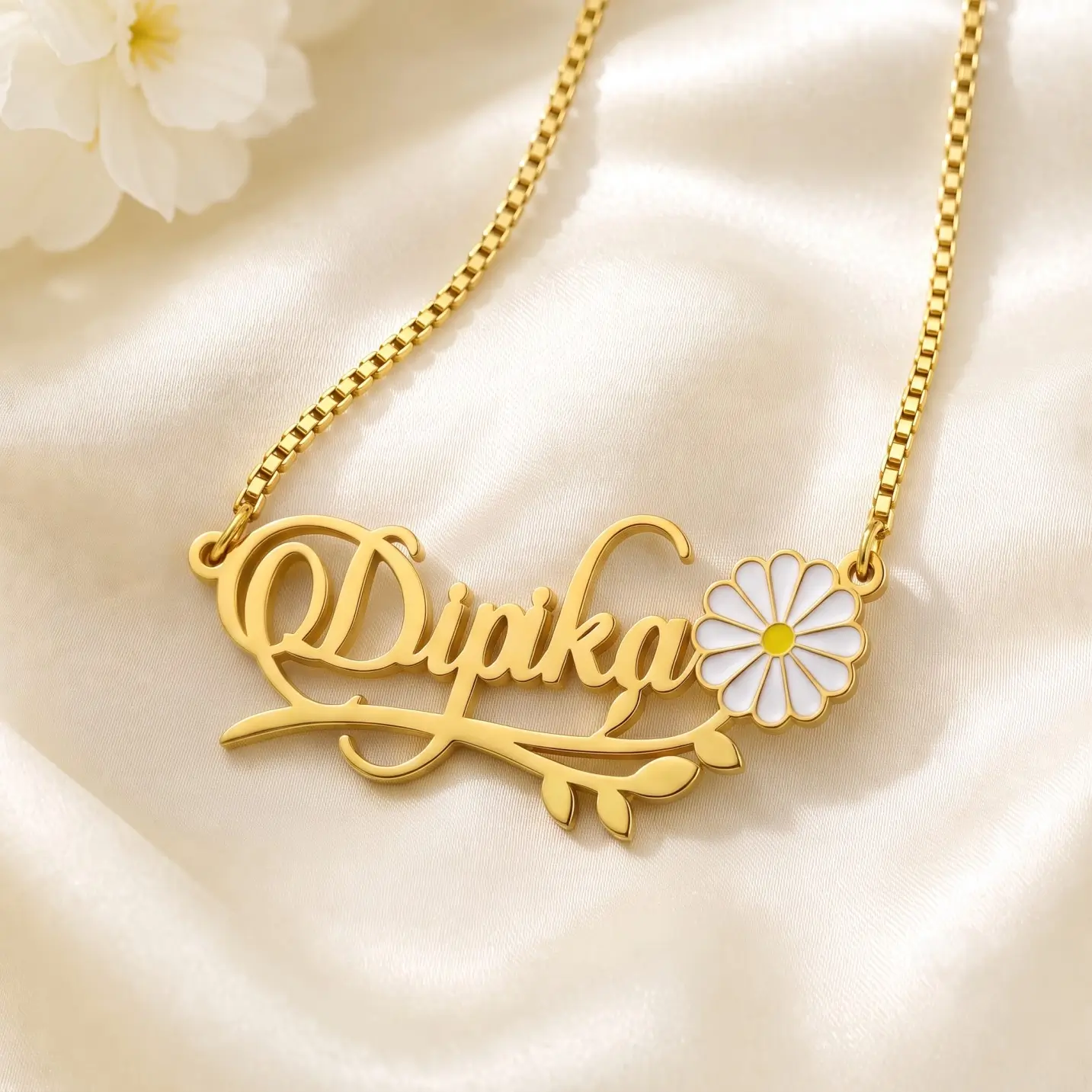 Flower and Leaf Name Necklace - Satin Detail Gold-tone daisy and leaf name necklace on ivory satin