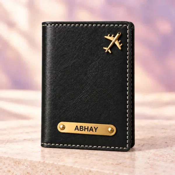 Black personalized passport cover with a golden nameplate and airplane detail, front view