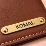 Close-up of the custom nameplate and stitching on a brown passport cover