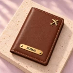 Brown custom name passport cover viewed at an angle on a stone display
