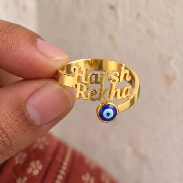 Personalized Evil Eye Couple Name Ring held between fingers to show the personalized design