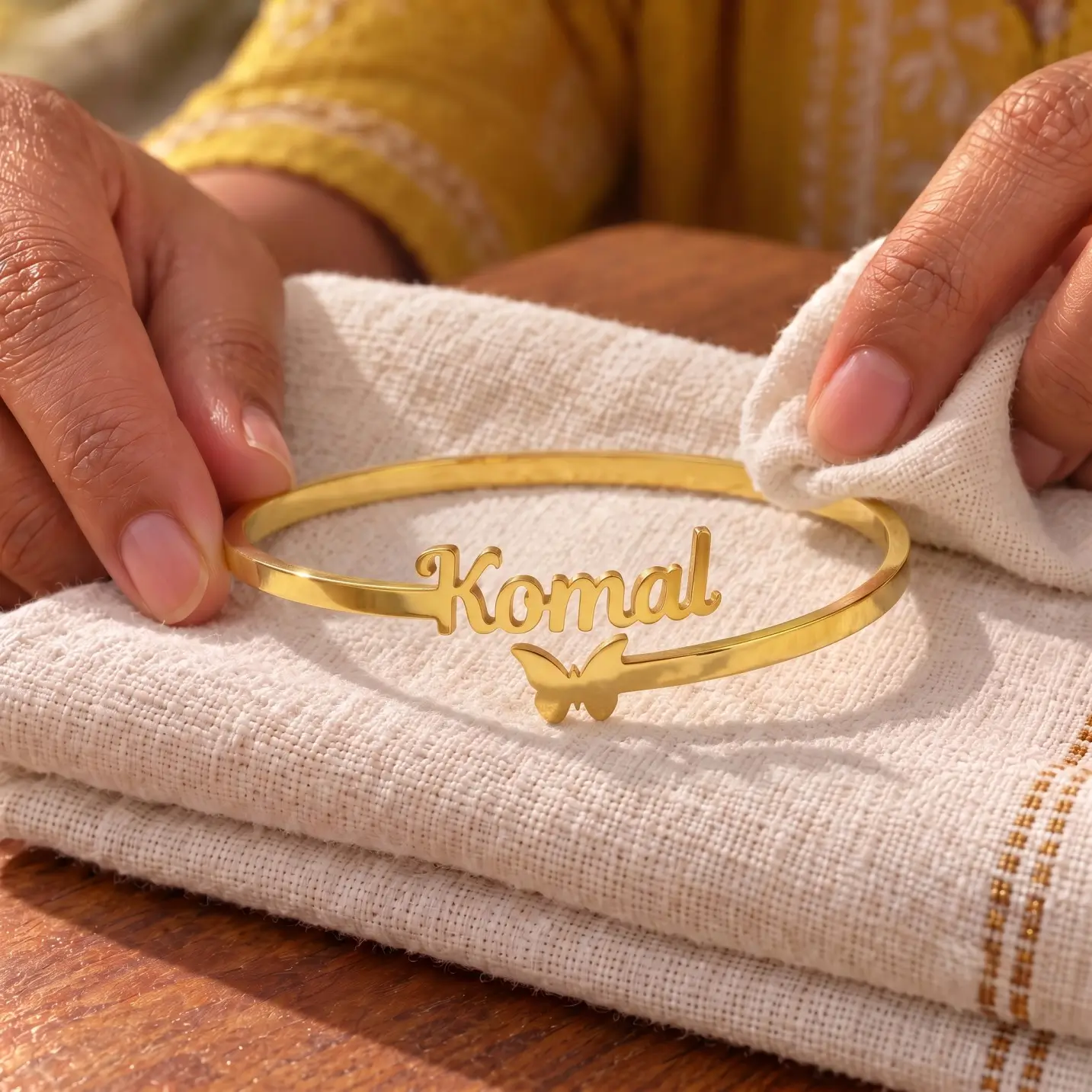 Personalized Butterfly Name Bracelet - Folded Fabric Display Personalized Butterfly Name Bracelet in a golden finish, displayed on folded cream fabric