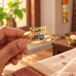 Personalized Evil Eye Couple Bracelet in a golden finish, held in a hand showing the name design