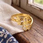 Two Hearts Personalized Love Ring displayed on beige linen beside a wooden window