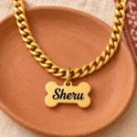 Gold-tone bone shape dog name pendant on a terracotta dish