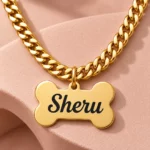 Personalized Bone Shape Dog Name Pendant with a gold-tone chain on a pink display