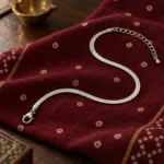 Silver Finish Snake Anklet with the extension chain visible on red fabric