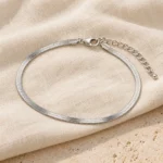 Silver Finish Snake Anklet with the clasp and extension chain on cream fabric