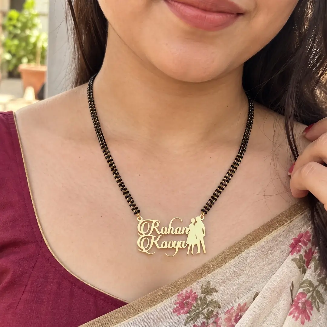 Standing Couple Name Mangalsutra Pendant - With a black-beaded chain worn with a sari Standing Couple Name Mangalsutra Pendant with a black-beaded chain worn with a sari