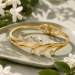 Golden Sparkle Bracelet with 6 Stones on a tray with white flowers
