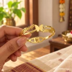 Golden Butterfly Leaf Cuff Bracelet held in a hand showing the front design and hinged fastening