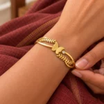 Golden Butterfly Leaf Cuff Bracelet worn on a wrist against maroon fabric