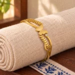Golden Butterfly Leaf Cuff Bracelet displayed around a rolled ivory linen cloth
