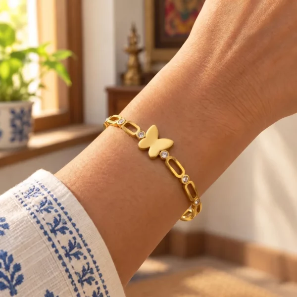 Golden Butterfly Link Bracelet worn on a wrist beside a blue and white sleeve