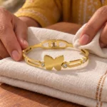 Golden Butterfly Link Bracelet displayed on folded ivory linen
