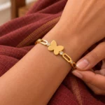 Golden Butterfly Link Bracelet worn on a wrist against maroon fabric