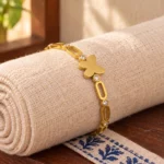 Golden Butterfly Link Bracelet displayed around a rolled ivory linen cloth