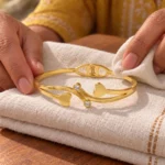 Golden Double Heart Cuff Bracelet displayed on folded ivory linen