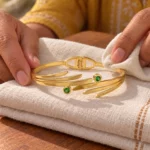 Golden Green Stone Leaf Cuff Bracelet displayed on folded ivory linen
