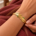 Golden Green Stone Leaf Cuff Bracelet worn on a wrist against maroon fabric