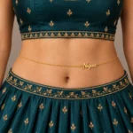 Gold-tone personalized Niyaa name waist chain worn with a teal embroidered lehenga