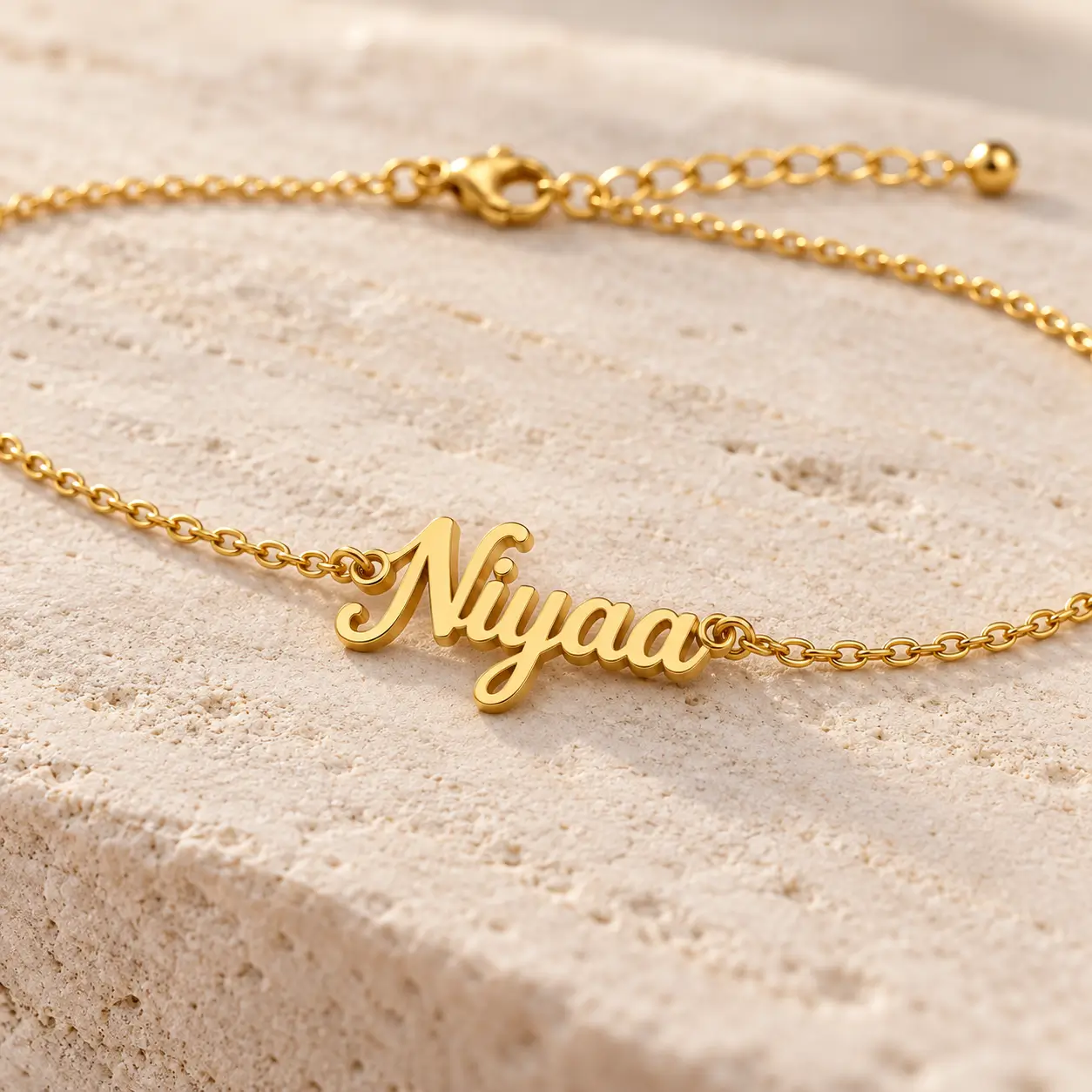 Personalized Cursive Name Waist Chain - Cursive Nameplate Close-up Close-up of gold-tone Niyaa cursive nameplate and fine links on a personalized waist chain