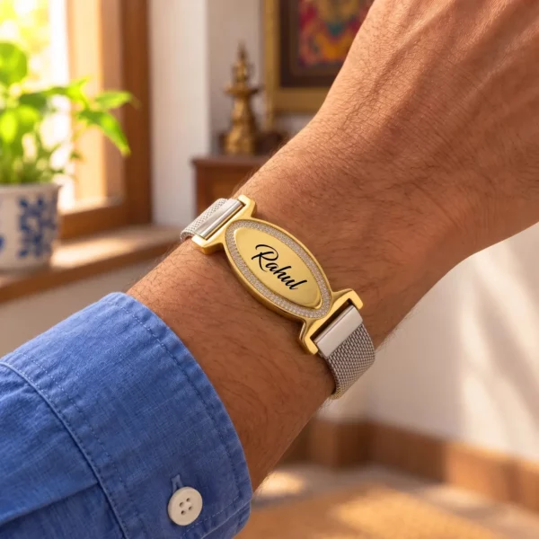 Personalized engraved name mesh bracelet with a golden oval nameplate, worn with a blue shirt