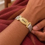 Close-up of a personalized oval nameplate mesh bracelet worn on the wrist